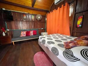 1 dormitorio con 1 cama y un banco en una habitación en Cabaña Caminito- Cerca al mar al lado de Turipaná, 7 a 12 personas, en Carretal