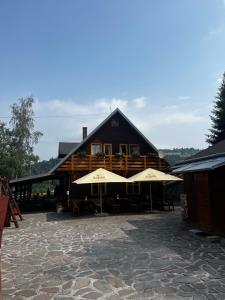 un gran edificio con dos sombrillas delante en SKI CIERNY BALOG en Čierny Balog