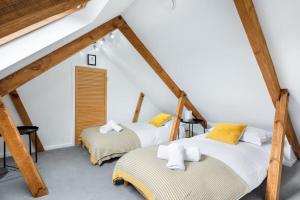 two beds in a attic room with wooden beams at Spacious, Modern Home, Central Newquay w/ parking in Newquay