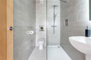 a bathroom with a shower with a toilet and a sink at Spacious, Modern Home, Central Newquay w/ parking in Newquay +26 photos