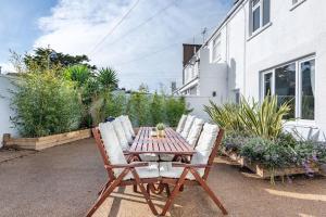 a wooden table with four chairs around it at Spacious, Modern Home, Central Newquay w/ parking in Newquay