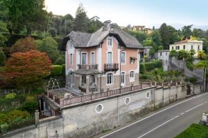une maison sur un mur à côté d'une route dans l'établissement villa rosa, à Baveno