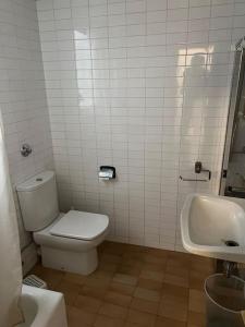 y baño con aseo y lavamanos. en Gran piso Terrassa centro rambla 5 habitaciones, en Terrassa