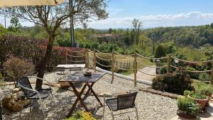 un patio con mesa, sillas y una valla en Agriturismo Tre Tigli, en Asti