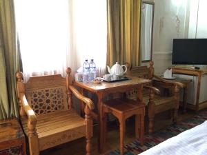 a room with a table and chairs and a television at Emir in Bukhara