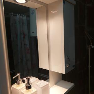 uma casa de banho com um lavatório branco e um espelho. em Apartmani Bogatić em Bogatić