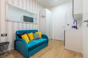 a blue couch with yellow pillows in a living room at Apartments & rooms SIX in Rijeka +37 photos