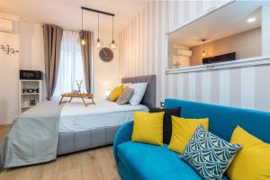 a bedroom with a blue couch and a mirror at Apartments & rooms SIX in Rijeka