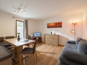 ein Wohnzimmer mit einem Tisch und einem Sofa in der Unterkunft Appartement Elisabeth in Ramsau im Zillertal