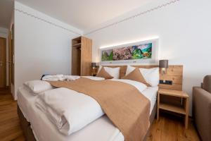 una camera da letto con un grande letto con lenzuola bianche di Hotel Gasthof Klause Dependance 2 a Reutte
