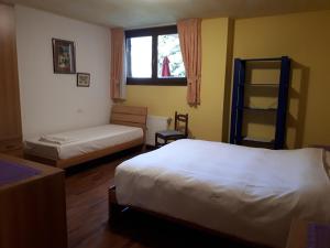 a bedroom with two beds and a window at Appartamento Presanella in Passo del Tonale