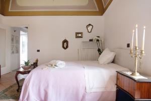 a bedroom with a large white bed with pink sheets at Dimora Ettore - Lago Maggiore in Casalzuigno