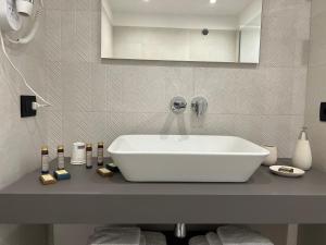 a bathroom with a white sink on a counter at RoccaRegina Hotel in Sciacca