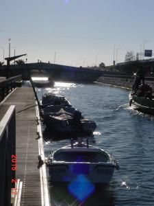 three boats are docked next to a dock on a river at SaberAmar City & Ria & More in Aveiro