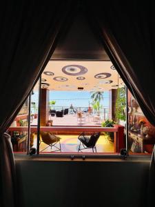 a room with a view of a balcony with two chairs at Kabatukila Pousada in Natal