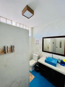 uma casa de banho com um lavatório, um WC e um espelho. em Kabatukila Pousada em Natal