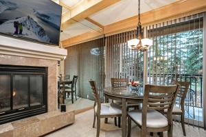 a dining room with a fireplace and a table and chairs at Vail Antlers 2 Bedroom Condo in Vail