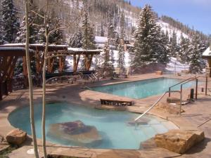 a swimming pool in a resort with a snow covered mountain at Vail Antlers 2 Bedroom Condo in Vail