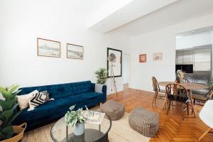 a living room with a blue couch and a table at Unique 2 Bedroom Flat on Stoke Newington High Street in London