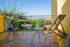 dwa krzesła i stół na balkonie z kwiatami w obiekcie Room in Villa - The white-orange bedroom with a pleasant view overlooking the lake w Antananarywie