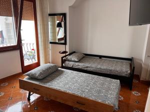 una camera con due letti e un tavolo e una finestra di Casa Dora ad Anacapri
