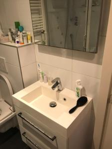 a bathroom with a sink and a toilet and a mirror at Bed & Breakfast Klokgaaf in De Koog +49 photos