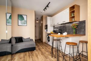 a living room and kitchen with a couch and a table at AYCON APARTMENTS - MODERN SPACE in Warsaw