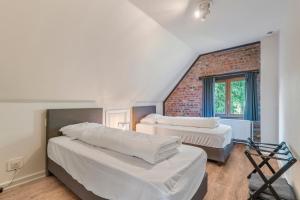 sypialnia z 2 łóżkami i ceglaną ścianą w obiekcie Fantastische vakantiewoning aan het bos w mieście Wingene