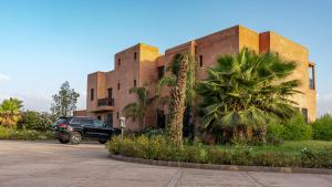 a car parked in front of a building with palm trees at Domain The blaze in Marrakech