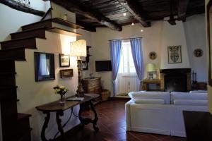 sala de estar con sofá blanco y mesa en Sui tetti del borgo, en Capranica