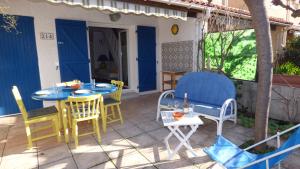 a patio with chairs and a table and chairs at Joli Pavillon 2** Narbonne Plage in Narbonne-Plage