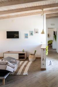 a living room with a couch and a tv on a wall at B&B Agramonte in Ispica