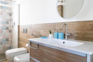 a bathroom with a sink and a toilet and a mirror at B&B Agramonte in Ispica