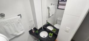 a bathroom with two sinks and potted plants in it at Lindo Apartamento compacto na quadra da praia in Santos +8 photos
