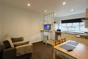 a kitchen and a living room with a couch and a table at One-Bedroom flat in Cheam Village in Cheam