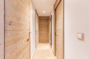 un pasillo con paredes de madera y una puerta en Résidence l'Hévana - Appartements de Prestige Méribel Centre en Méribel