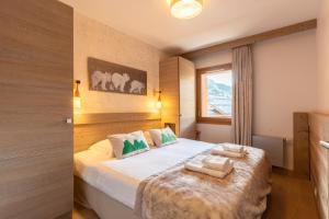 1 dormitorio con 1 cama con 2 toallas en Résidence l'Hévana - Appartements de Prestige Méribel Centre en Méribel