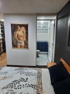 um quarto com uma pintura na parede e uma casa de banho em Hospedaje Aguaclara em Quito