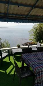 einen Tisch und Stühle mit Blick auf das Wasser in der Unterkunft Sakin ev Cittaslow Sea Inn in Perşembe