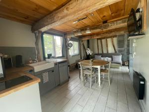 eine Küche und ein Esszimmer mit einem Tisch und Stühlen in der Unterkunft La maison du Bonheur "LE GITE" in Saint-Ouen-sous-Bailly