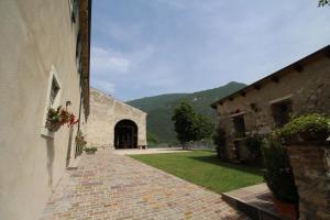 een bakstenen pad dat leidt naar een gebouw met een deuropening bij Agriturismo Antico Fenilon in Brentino Belluno