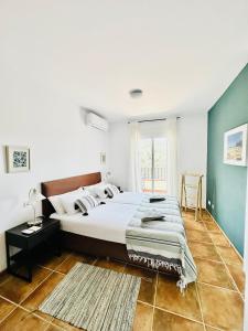 a bedroom with a bed and a green wall at La Perla de Frigiliana Suites & Villa in Frigiliana