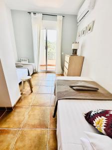 um quarto com 2 camas e piso em azulejo em La Perla de Frigiliana Suites & Villa em Frigiliana