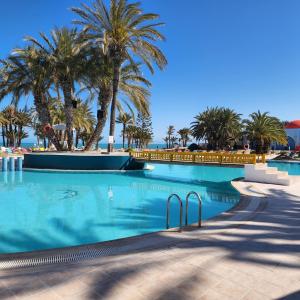 basen z palmami w tle w obiekcie Golf Beach & Thalasso- Families and Couples w mieście Triffa