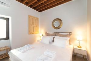 1 dormitorio con 1 cama blanca y 2 toallas en Villa Danae - Lindos, en Lindos