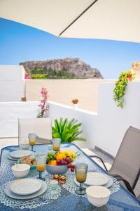 林都斯的住宿－Villa Danae - Lindos，一张桌子,上面放着一碗水果和橙汁