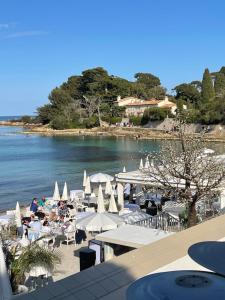 una spiaggia con sedie, ombrelloni e acqua di Chez Ventura a Barjols