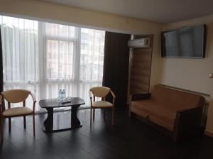a living room with a couch and a table and chairs at Hotel LUDMIR in Volodymyr-Volynskyi