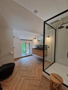 een kamer met een spiegel en een houten vloer bij Habitat in Momignies