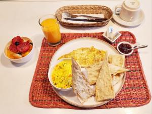 a breakfast plate of eggs and toast and a glass of orange juice at Lima Wari Hotel Boutique in Lima